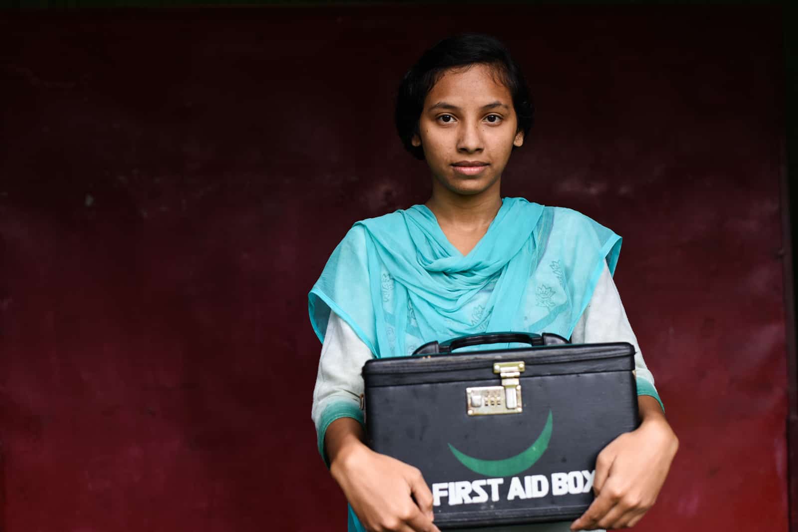 Fille en bleu Une adolescente tient une trousse médicale