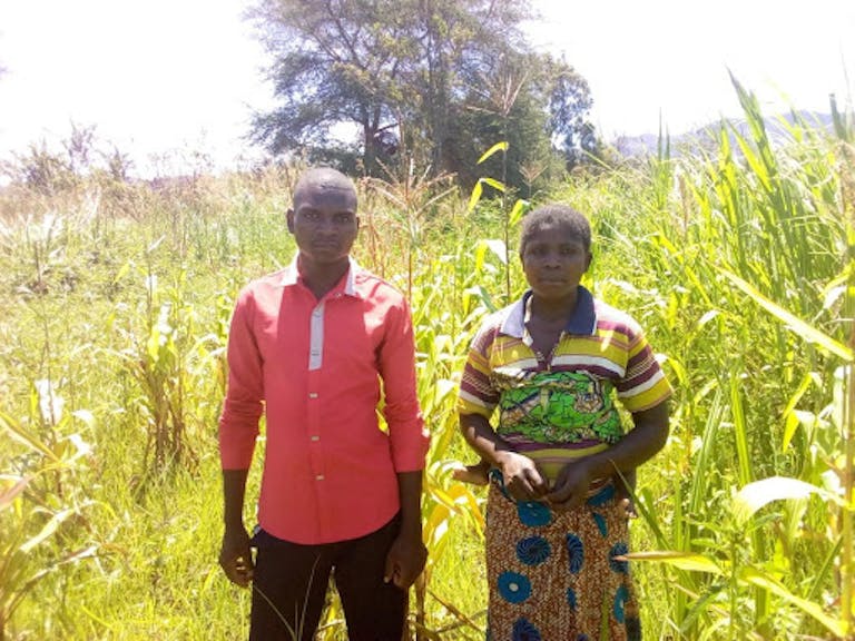Illdephonse (à gauche) se tient dans son champ avec la femme de son voisin Mapenzi.