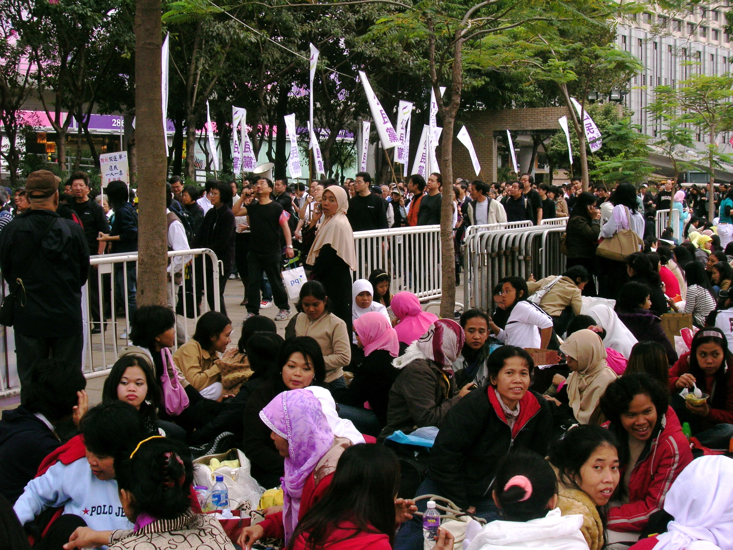 Des employées domestiques indonésiennes se détendent dans un parc de Hong Kong, assises ensemble. Les travailleurs domestiques migrants de Hong Kong