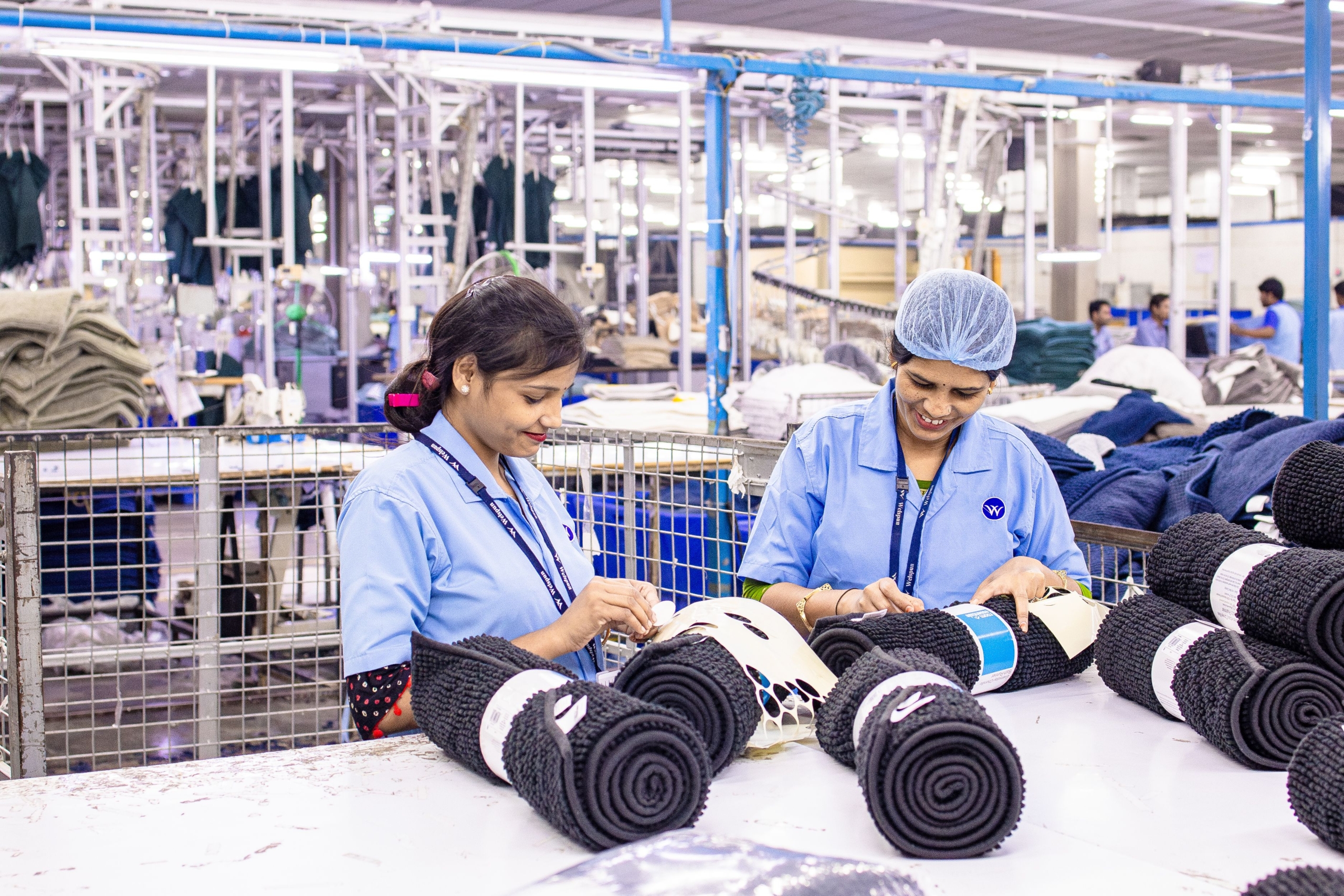 Femmes travaillant dans une usine textile éthiopienne, roulant des tissus colorés. L'industrie textile éthiopienne