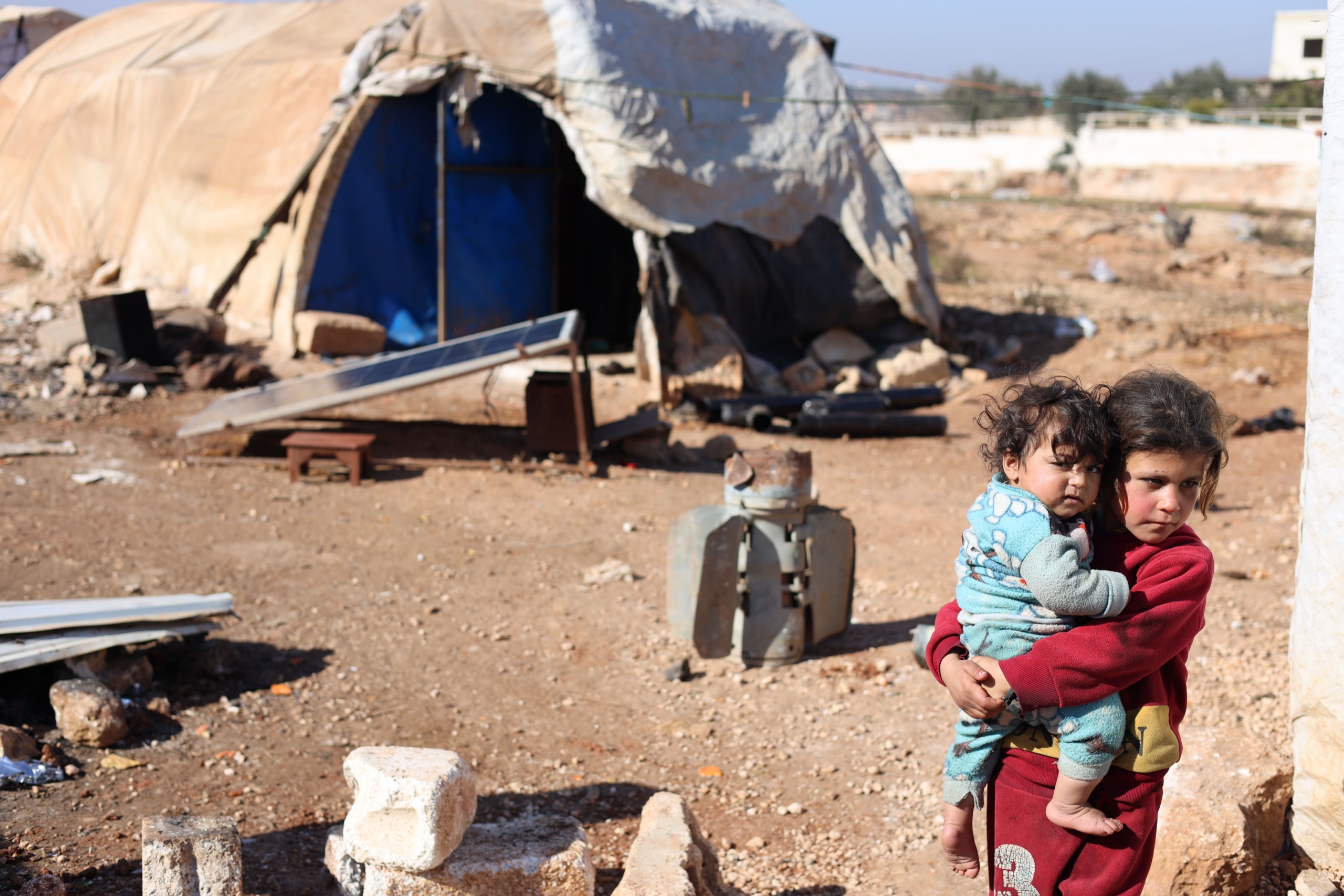 Enfants dans un camp de réfugiés syriens, mettant en lumière les initiatives humanitaires des ONG. ONG travaillant en Syrie